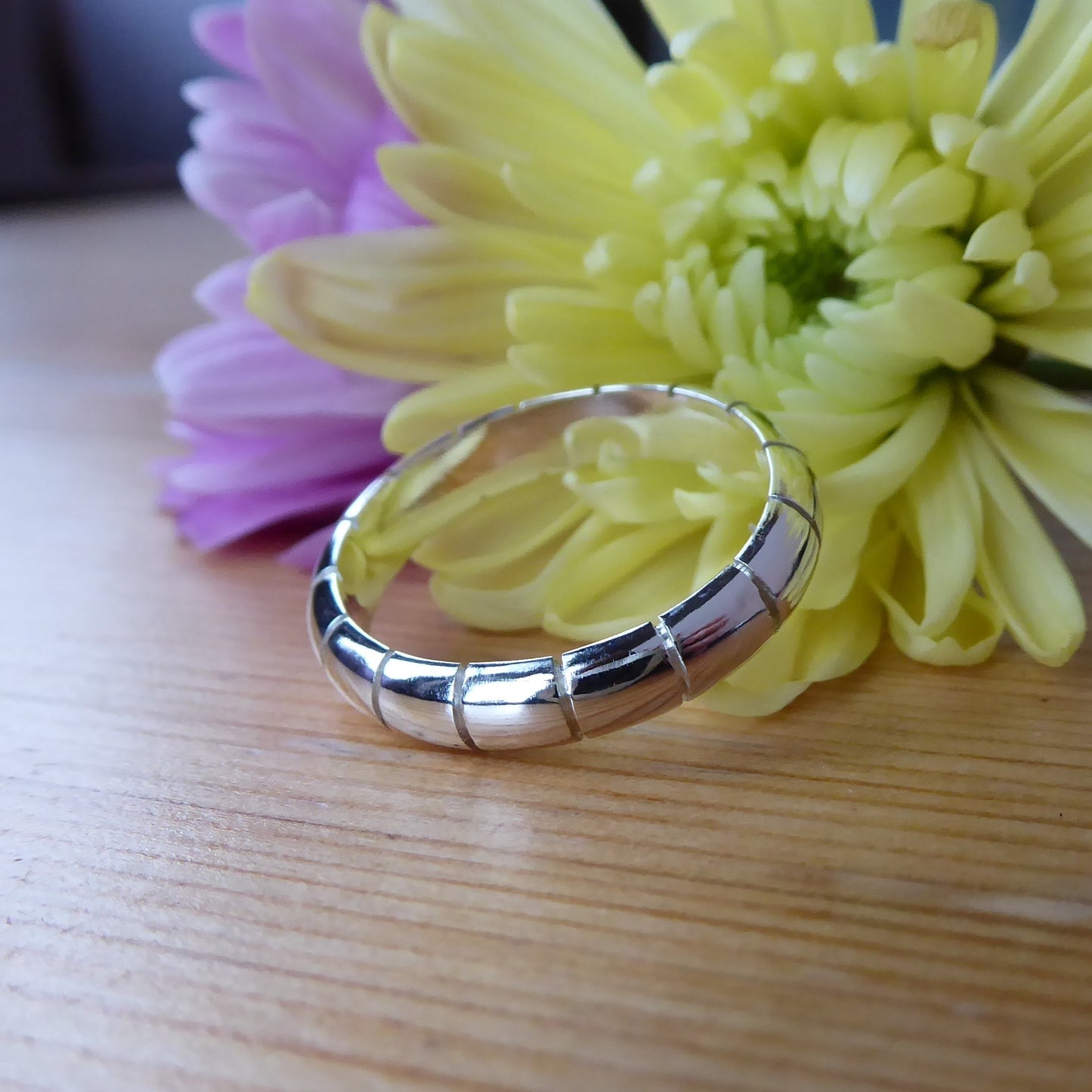Solid D shaped band with hand-sawn striped detail repeat pattern around the band. Made from recycled 925 Sterling Silver.